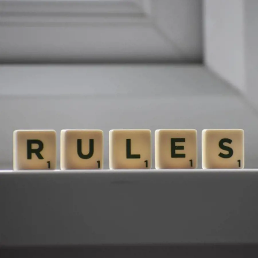 Het woord 'Rules' gespeld met Scrabble-achtige stenen op een lichte achtergrond.