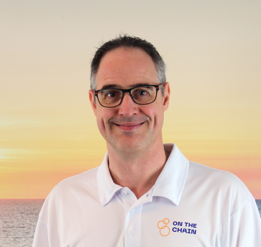 Een portret foto van Dominique Verweij in een witte polo met de logo van On The Chain op zijn borst.